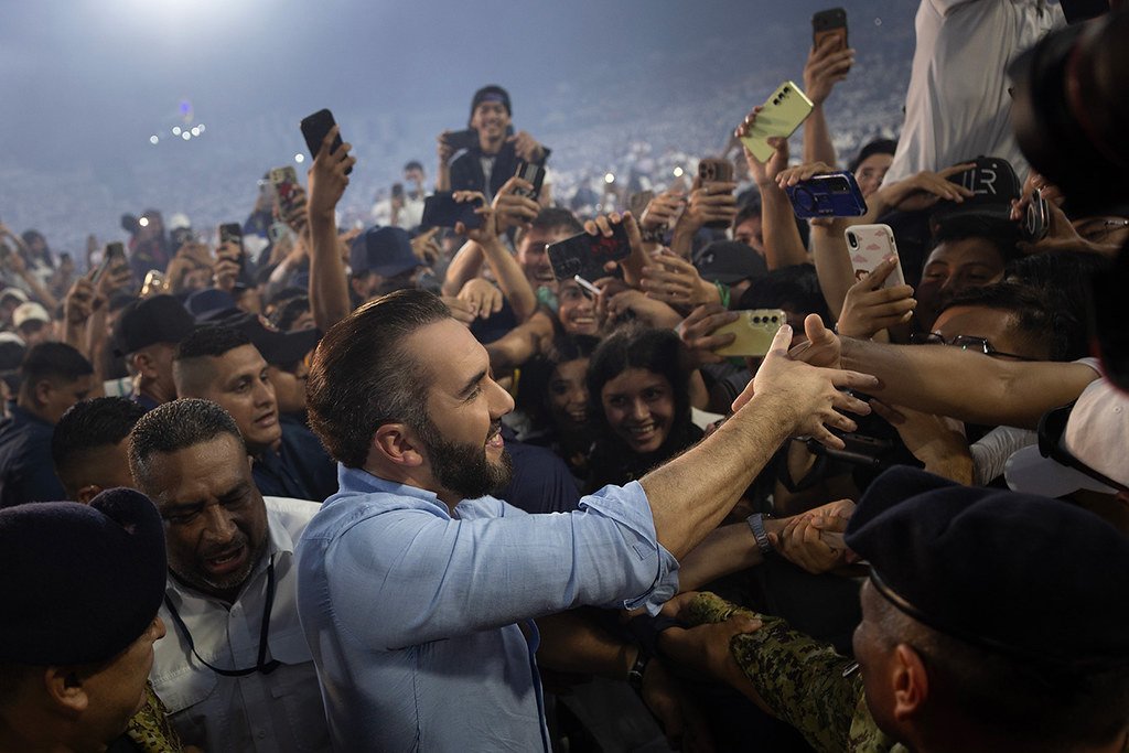 El presidente Nayib Bukele saluda a decenas de estudiantes que lo rodean con sus teléfonos en alto en el estadio Mágico González
